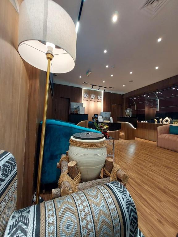 a living room with a floor lamp and a couch at AG Hotel in Abu Dhabi