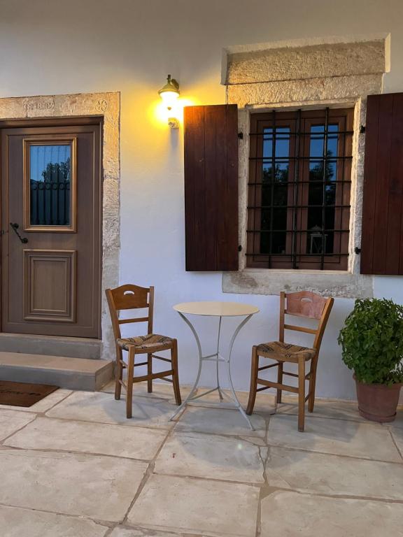 a table and chairs in front of a door at Madaro Traditional House in Arménoi