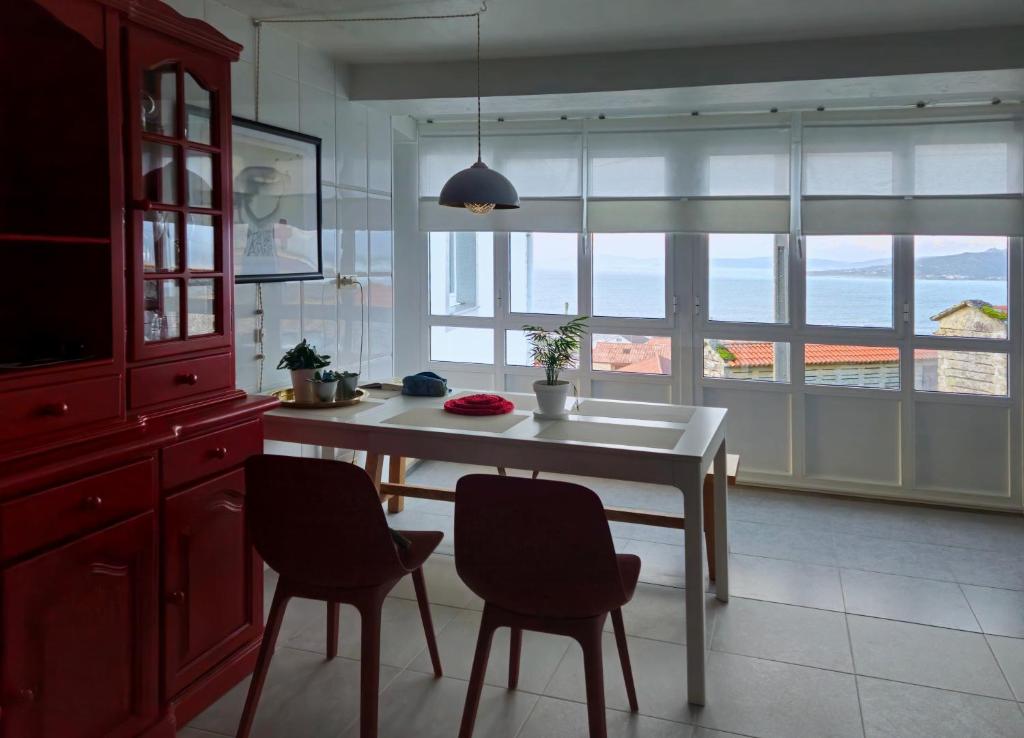 a kitchen with a table and chairs and a window at Miradoiro 38 in Lira