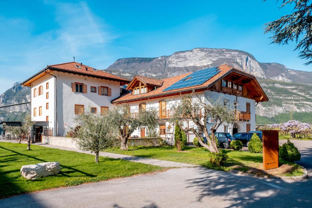 a house with a roof with a mountain in the background at Antico Fienile Agritur in Mezzocorona