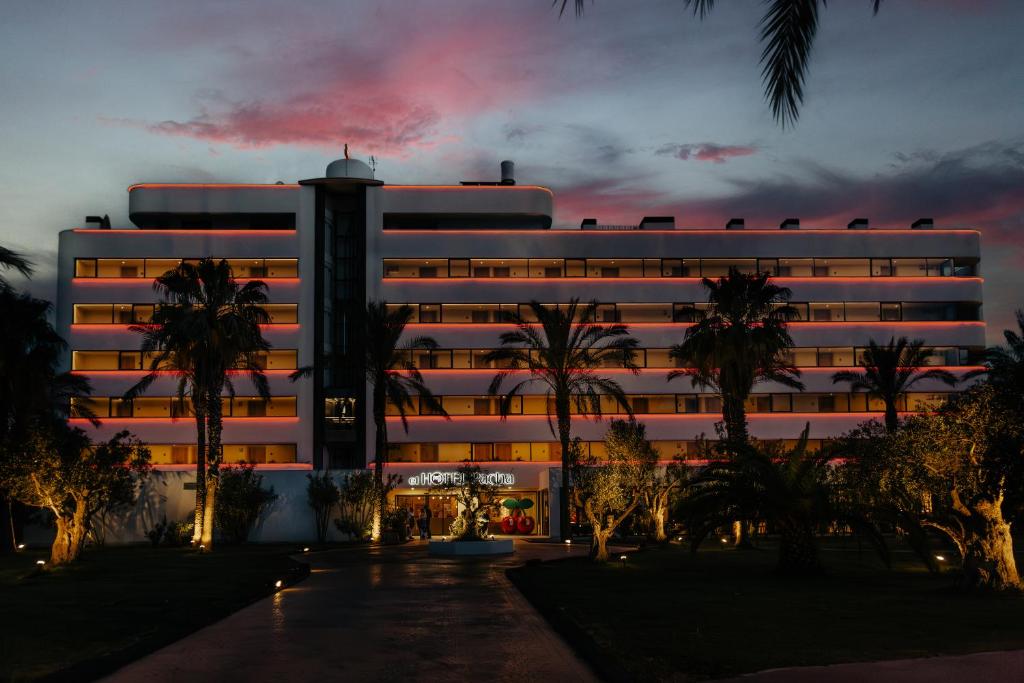 un edificio blanco con palmeras delante en El Hotel Pacha, en Ibiza