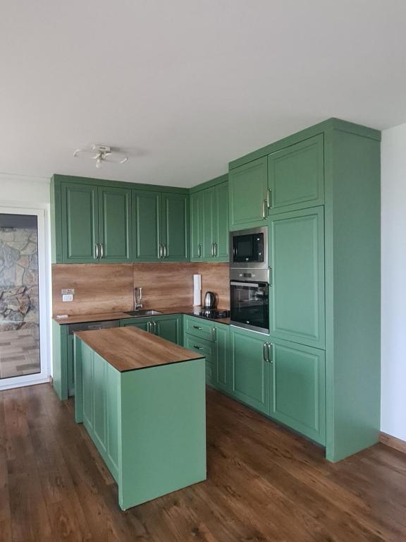 a green kitchen with green cabinets and a counter at Villa Ozoni 2 - Jezerc in Ferizaj
