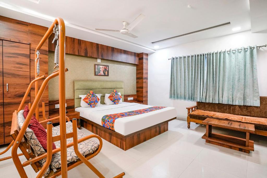 a bedroom with a bed and a bench at FabHotel Ratna Palace in Ahmedabad