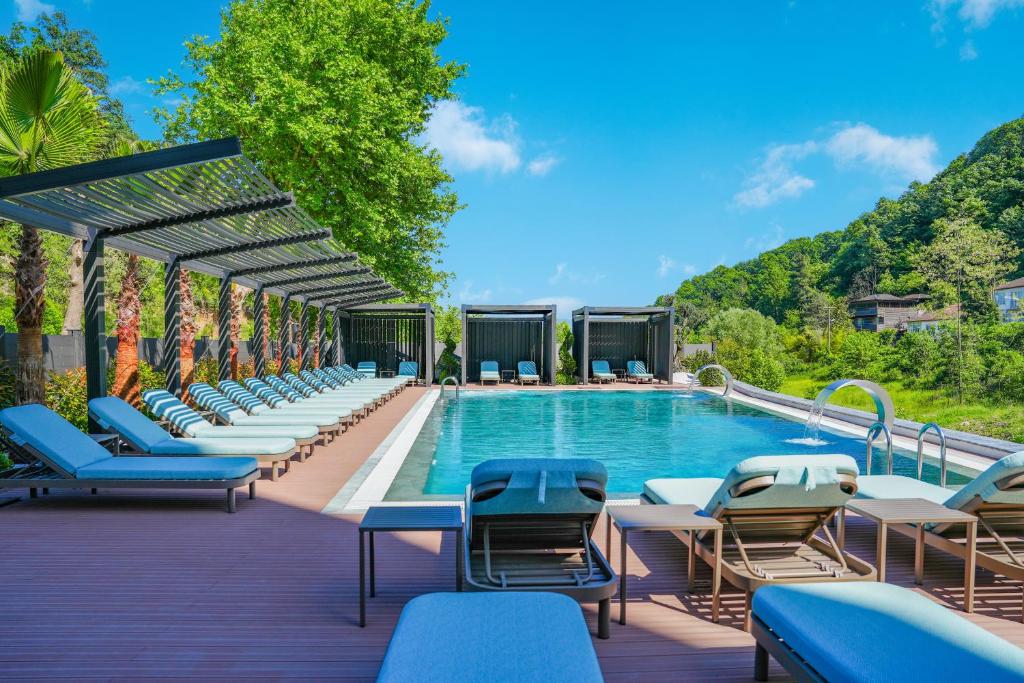 - une piscine dans un complexe avec des chaises longues dans l'établissement Vital Thermal Hotel & SPA, à Termal