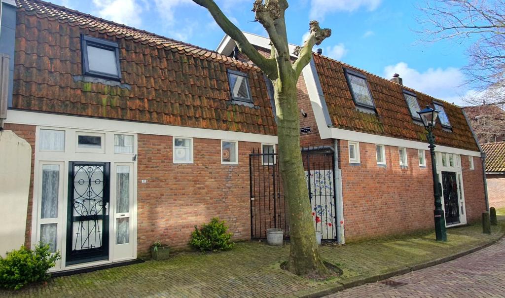 a brick house with a tree in front of it at Studio Nieuwland in Alkmaar