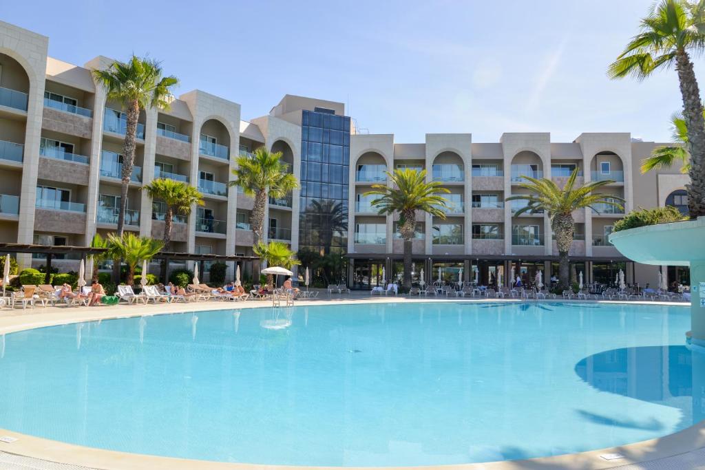 a large swimming pool in front of a resort at Falésia Hotel - Adults Only in Albufeira