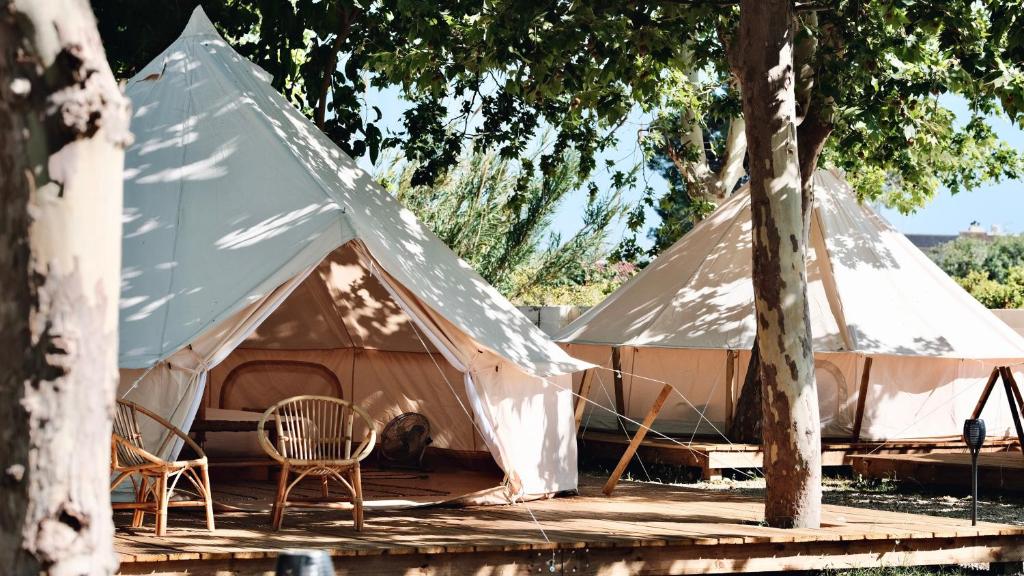 ein großes Zelt mit einem Stuhl und einem Baum in der Unterkunft HolaCamp Vendrell in Comarruga