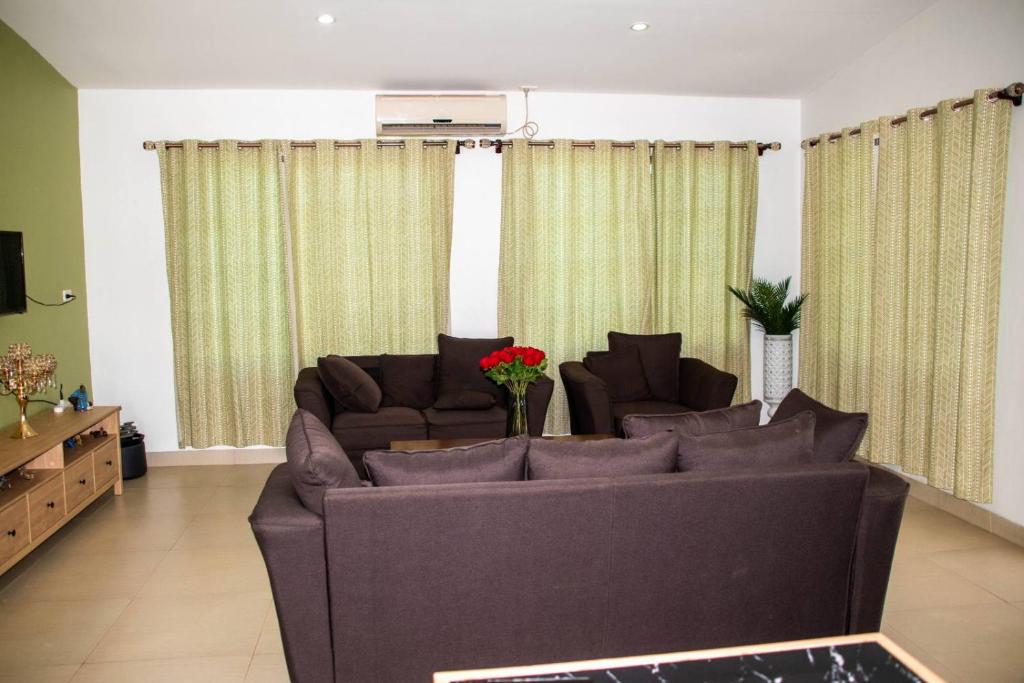 een woonkamer met een grote bank en gordijnen bij Fijian Homestay - 3 bedroom house in Nadi