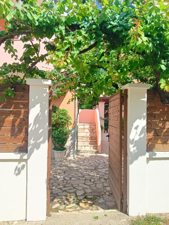 an entrance to a building with a gate and a tree at Voula's maisonette in Acharavi