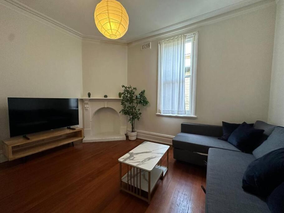 ein Wohnzimmer mit einem Sofa und einem Kamin in der Unterkunft Best Price 2 Bedroom House Glebe in Sydney