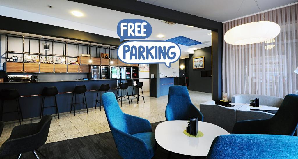 un restaurante con sillas azules y una señal de aparcamiento gratuita en Best Western Airport Hotel Stella, en Zagreb