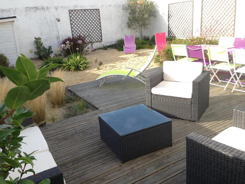 eine Terrasse mit Stühlen und Tischen auf einer Terrasse in der Unterkunft La Nantaise de la mer in Saint-Hilaire-de-Riez