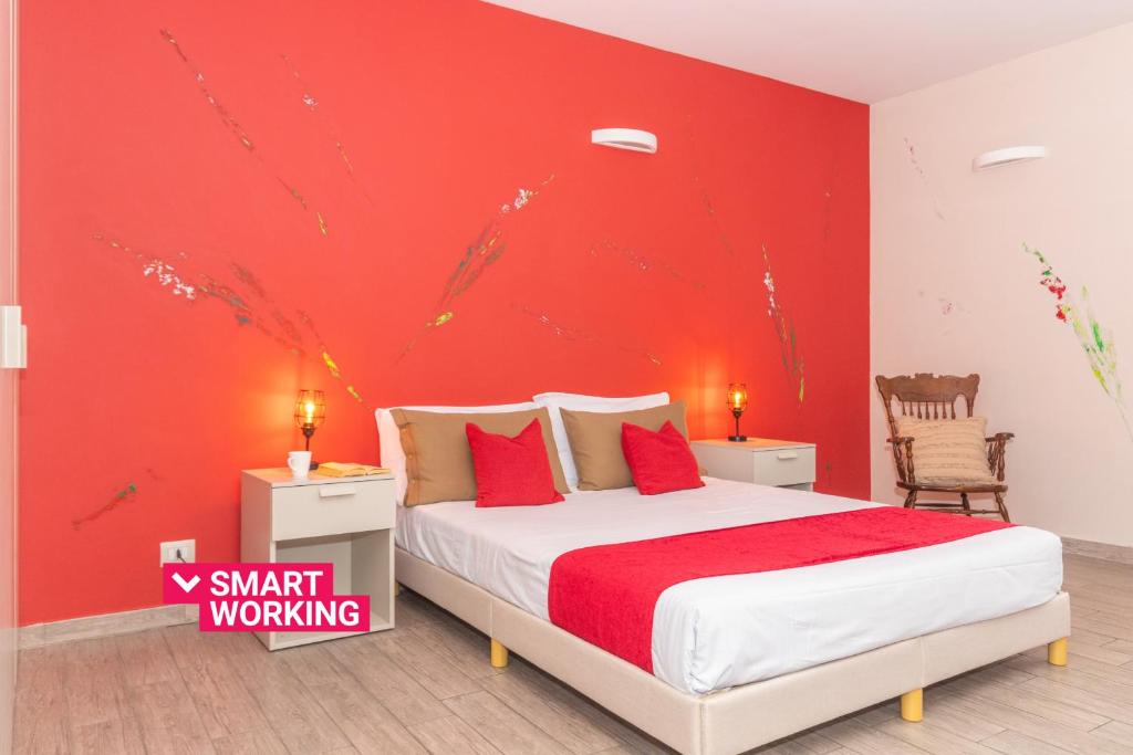 a bedroom with a bed with a red wall at Housing Giulia in Turin