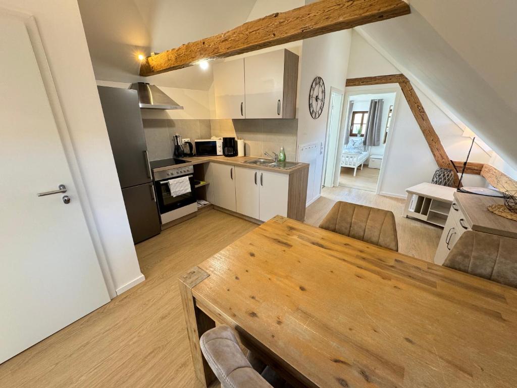 een keuken en een woonkamer met een houten tafel bij Pension Laurent Ranch in Gottfrieding