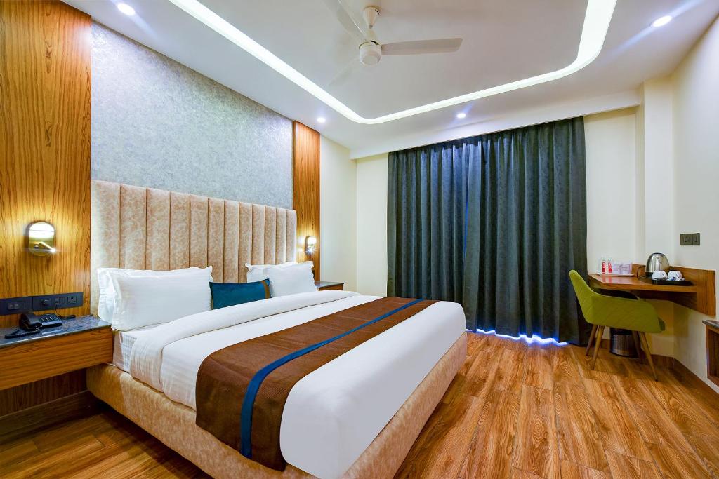 um quarto de hotel com uma cama grande e uma secretária em FabHotel Soft Petals em Gurgaon