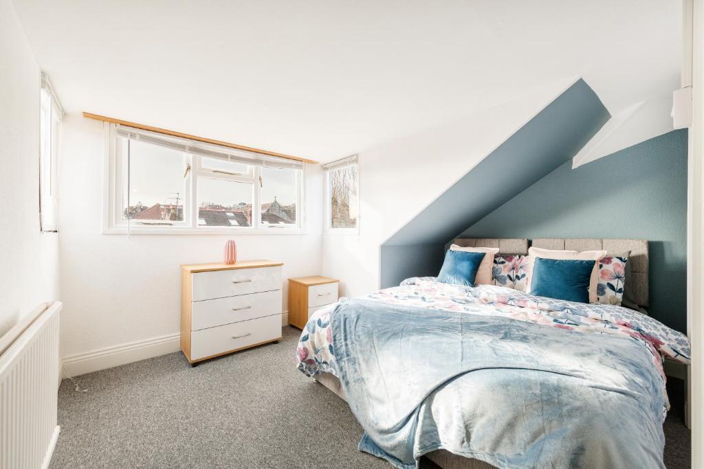 a bedroom with a blue and white bed and a window at Stunning 5-Bed Maisonette in Bristol in Bristol