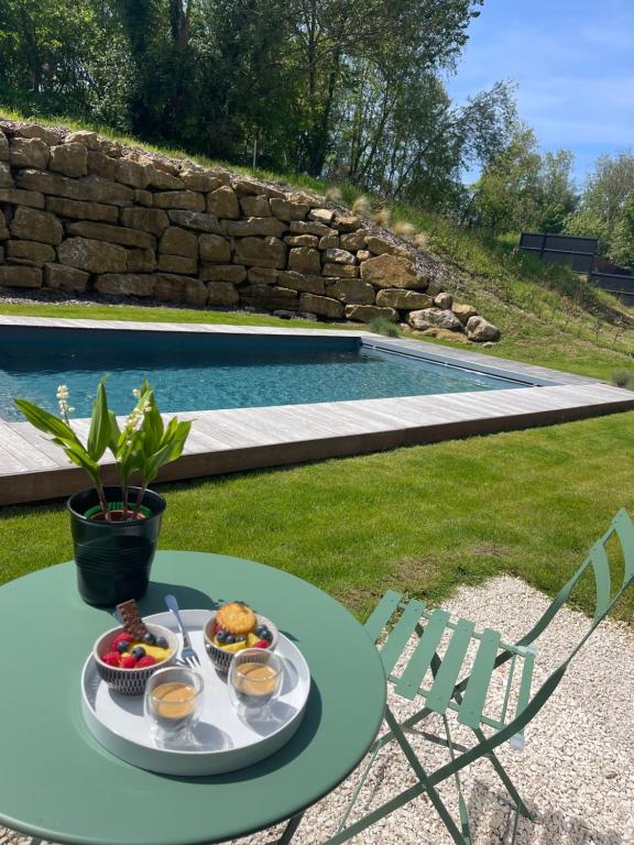 een dienblad met eten op een tafel naast een zwembad bij Parenthèse d'Opale in Wimille