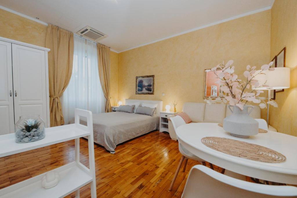a hotel room with a bed and a table at Rooms and Studios Villa Rossella 2 in Rovinj