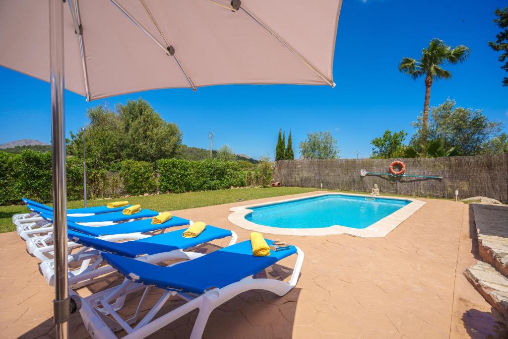 a group of chairs and an umbrella next to a swimming pool at Finca JESUS Pollensa in Port de Pollensa
