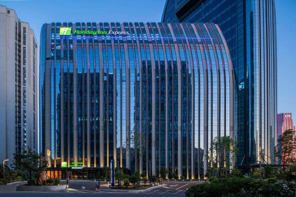 a tall glass building with a sign on it at Holiday Inn Express Changchun Ecological Square, an IHG Hotel in Changchun