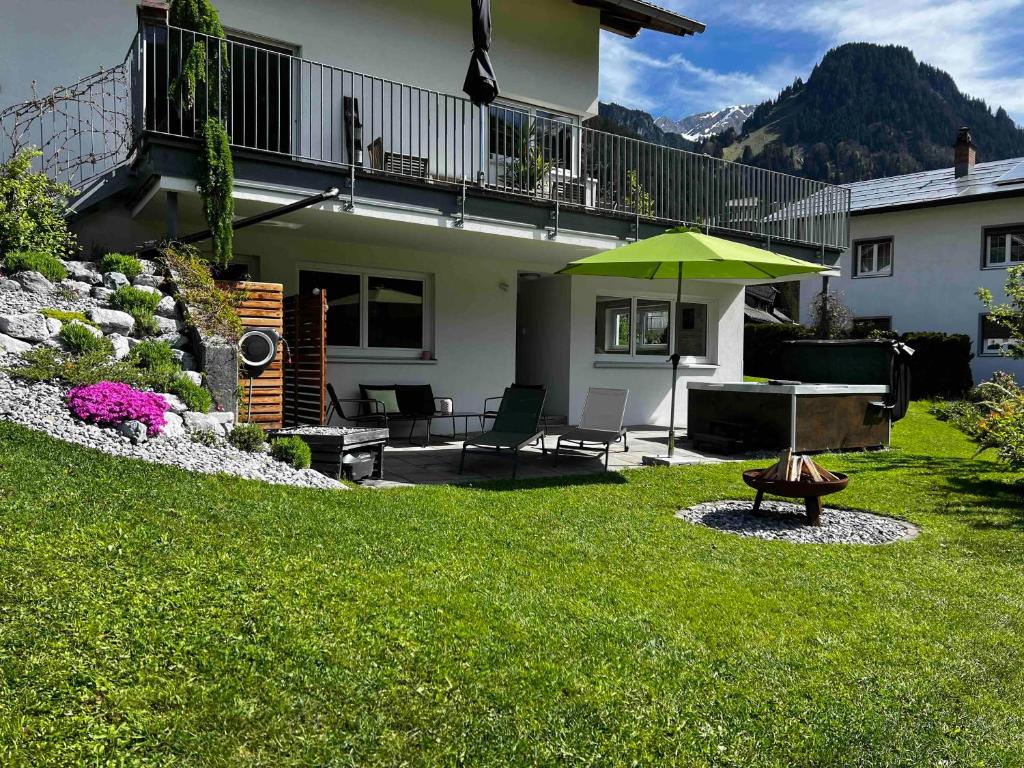 a patio with a table and an umbrella in a yard at apart belmonte in Wald am Arlberg