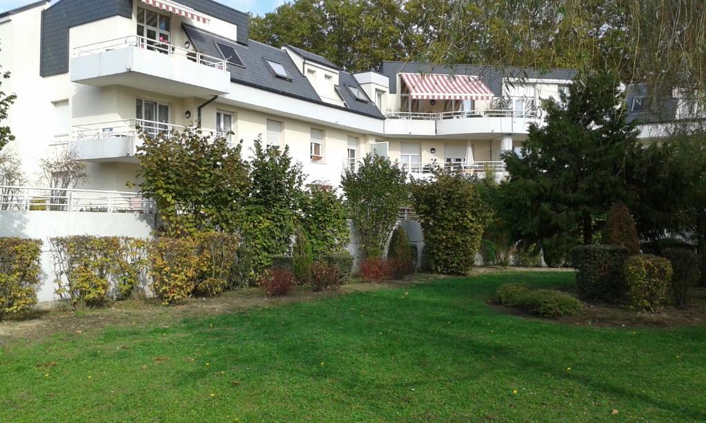 ein großes weißes Gebäude mit einem Hof davor in der Unterkunft Gîte Des Vergers in Illkirch-Graffenstaden