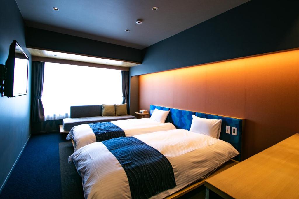 pokój hotelowy z 2 łóżkami i oknem w obiekcie Minn Nijojo w mieście Kioto