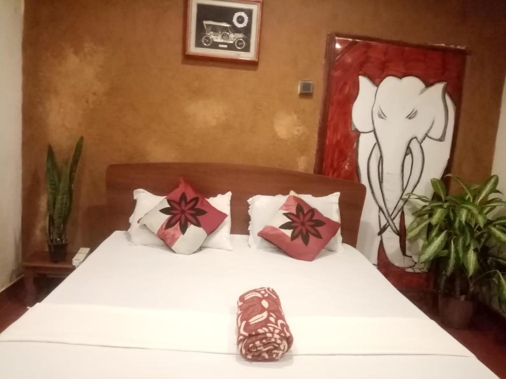 - une chambre dotée d'un lit blanc avec des oreillers rouges et blancs dans l'établissement Mystay, à Mawanella