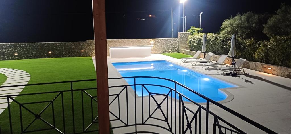 a swimming pool in a yard at night at Villa Maria in Porto Heli