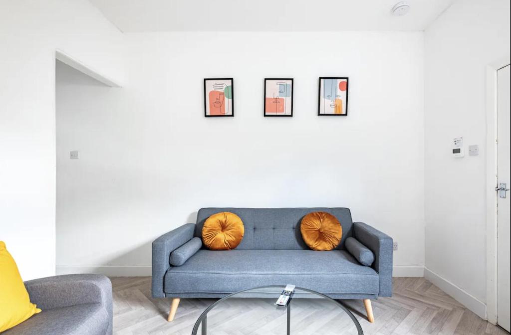 a living room with a blue couch with two orange pillows at Home Away From Home Local To A Lot Of Amenities in Stoke on Trent