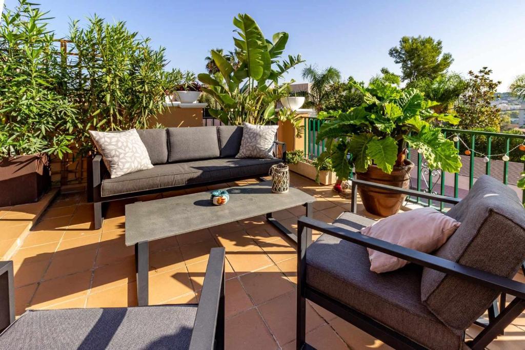 a patio with couches and a table on a balcony at Casa Alegría Casa premium piscina comunitaria in S'agaro