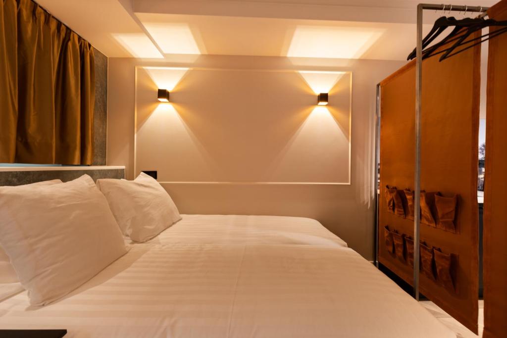 a bedroom with a bed with two lights on the wall at Midtown Hotel Royal Room in Amsterdam
