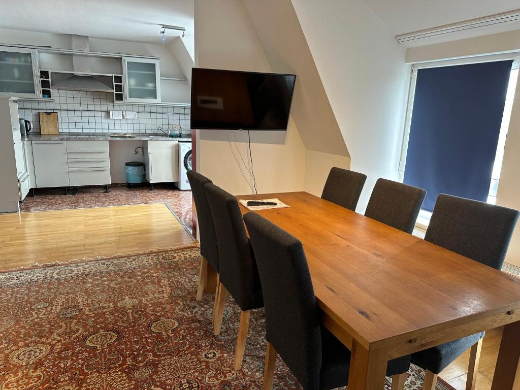 a dining room with a wooden table and chairs at Großes Apartment im DG in Leipzig