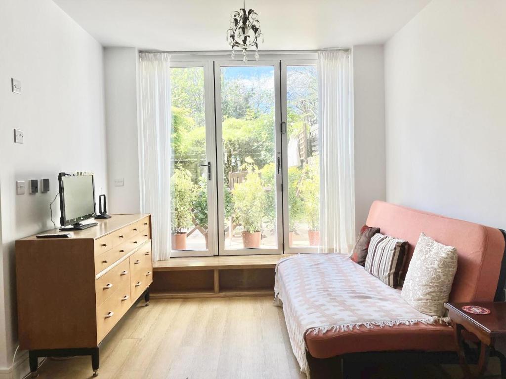 sala de estar con sofá y ventana grande en Bright 1BR Flat wPatio in Islington, Angel en Londres