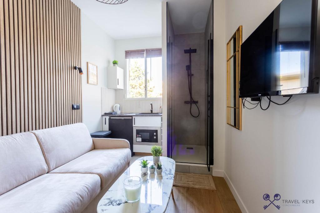 ein Wohnzimmer mit einem weißen Sofa und einem Tisch in der Unterkunft Neuilly sSeine - Inkermann in Neuilly-sur-Seine