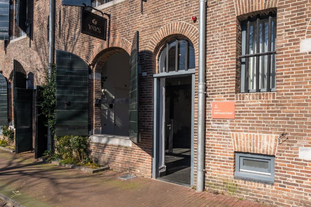 uma entrada para um edifício de tijolos com uma porta aberta em YAYS Amsterdam Salthouse Canal by Numa em Amesterdão