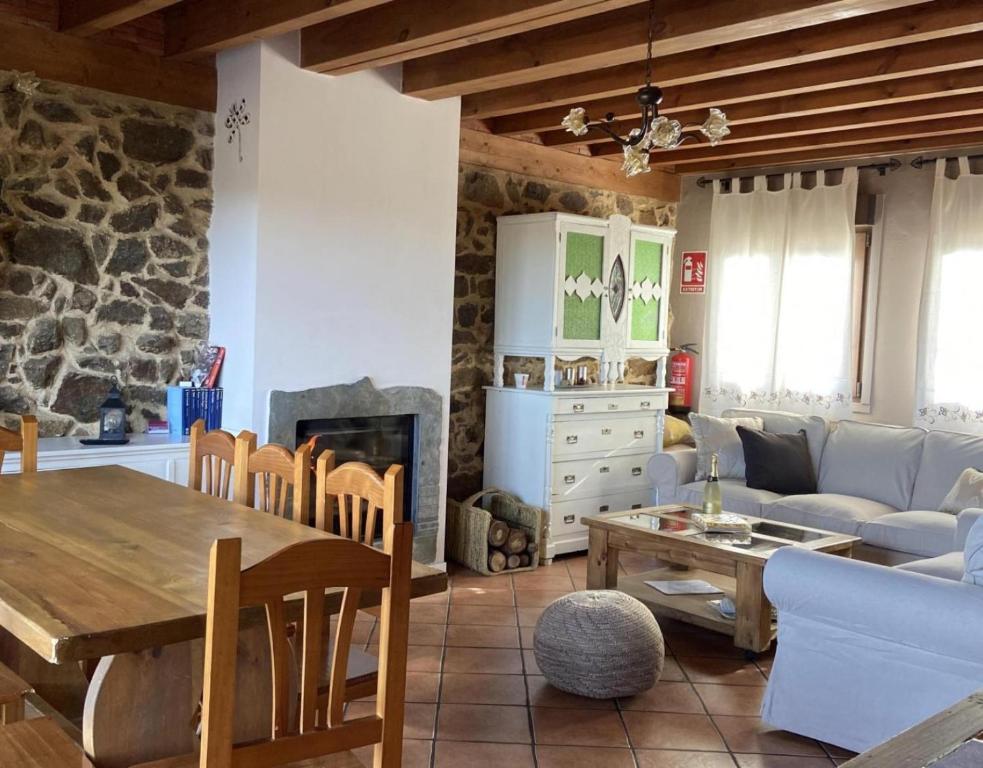 ein Wohnzimmer mit einem Tisch und einem Kamin in der Unterkunft Casa Rural Lucia in La Horcajada