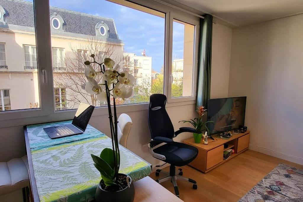 Cette chambre comprend un bureau avec un ordinateur portable et une chaise. dans l'établissement Charming 2 bedrooms ideal for Olympic Games Paris!, à Boulogne-Billancourt