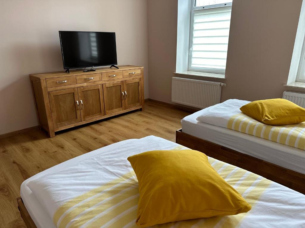 duas camas num quarto com televisão numa cómoda em Schöne 2 Raumwohnung in Borna em Borna