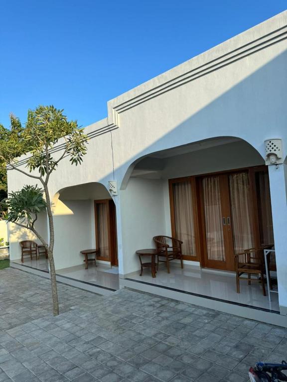 a building with benches and a tree in front of it at Simple Homestay Balangan in Jimbaran