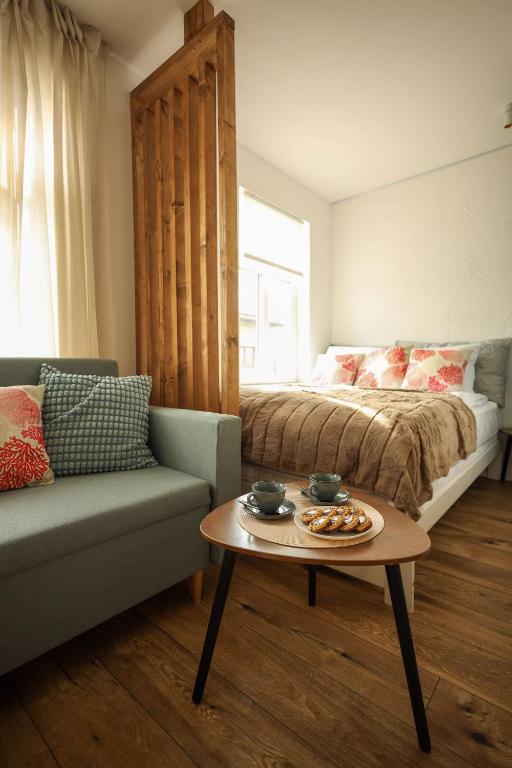a bedroom with a bed and a table and a couch at Seahorse apartment in Liepāja