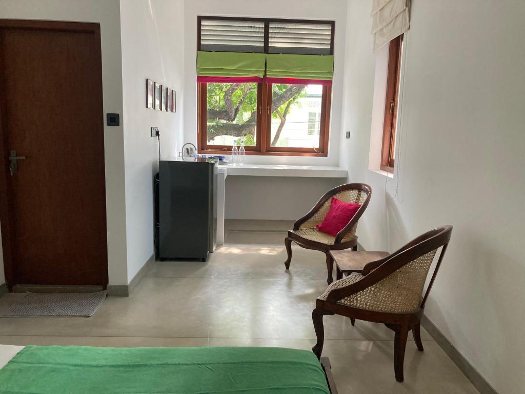 um quarto com 2 cadeiras e uma cozinha com um lavatório em Green Path em Colombo