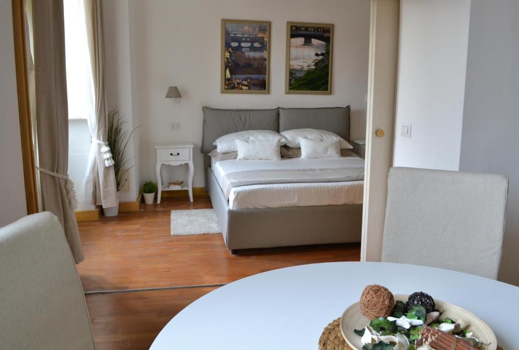 una camera da letto con un letto e un tavolo in una stanza di LE QUATTRO MURA EXCLUSIVE a Firenze