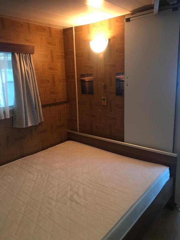 Cette chambre comprend un lit avec une porte et une fenêtre. dans l'établissement Goolderheide De Bochel 542, à Bocholt