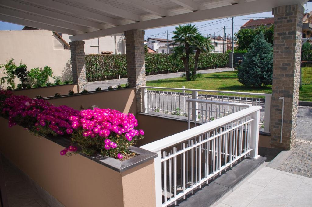 a balcony with pink flowers and a white railing at Dimora da Anna tra Amalfi e Sorrento in Angri