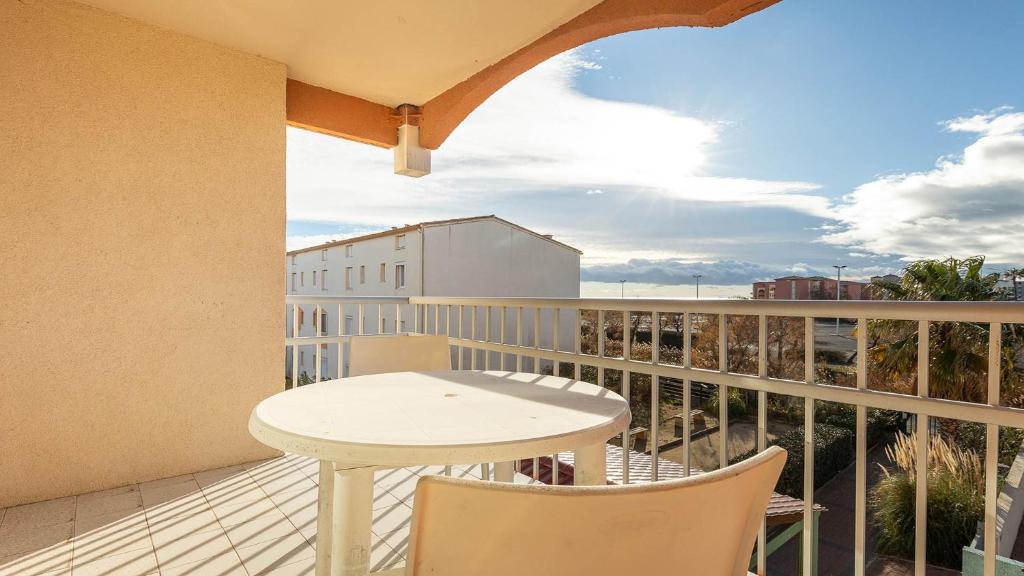 un balcon avec une table et des chaises et une vue dans l'établissement PRIMAVERA 202 Appt veranda 4 a 6 pers, au Cap d'Agde