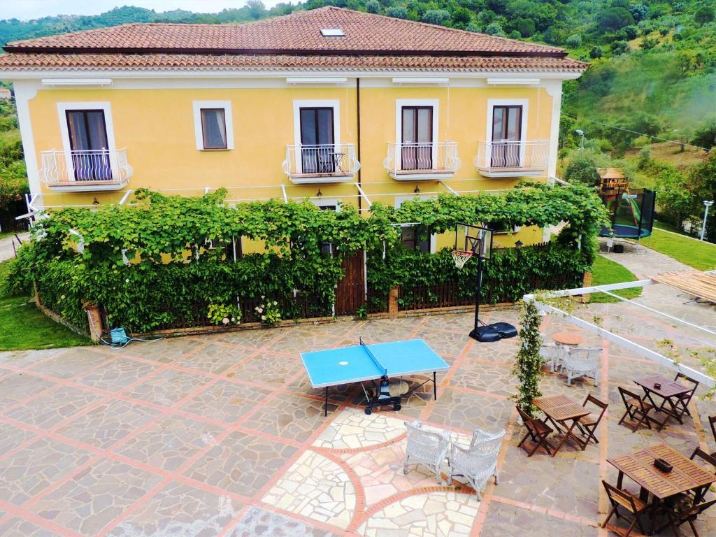 a yellow house with a blue table in front of it at That's Amore Cilento Country House in Agnone