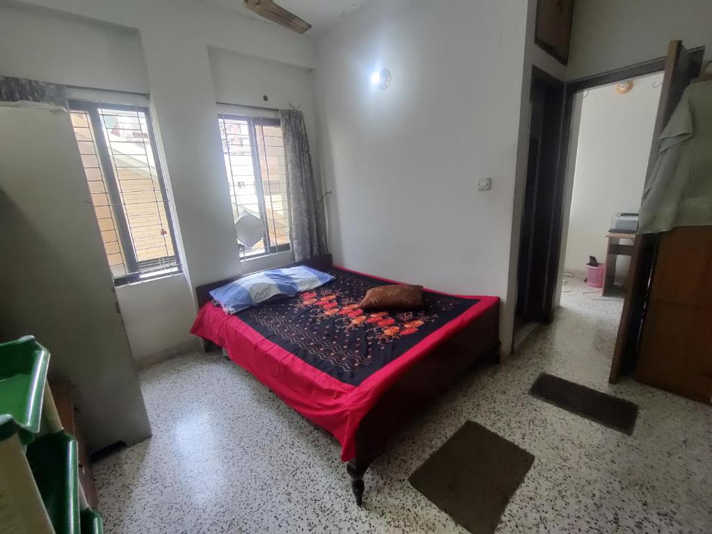 1 dormitorio con 1 cama en una habitación con 2 ventanas en Friend uttara, en Dhaka