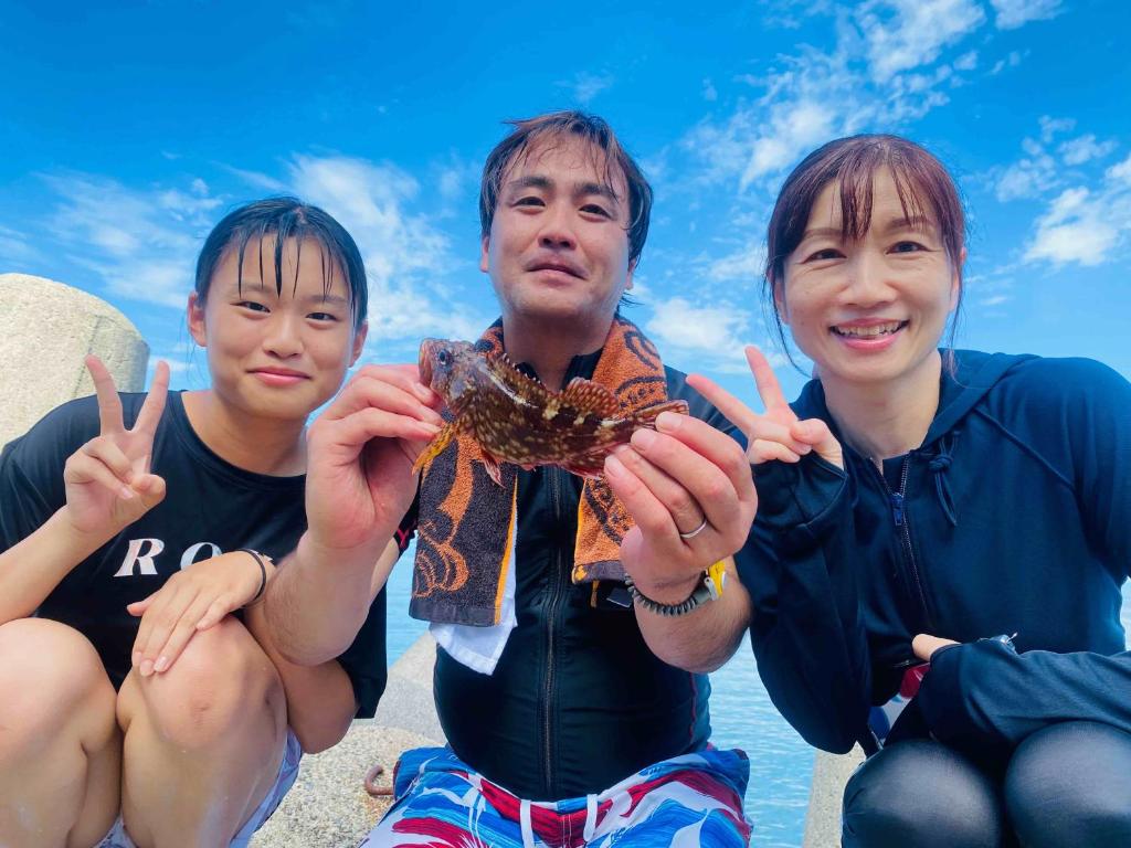 drei Menschen, die eine Krabbe in den Händen halten in der Unterkunft Awakan in Sumoto