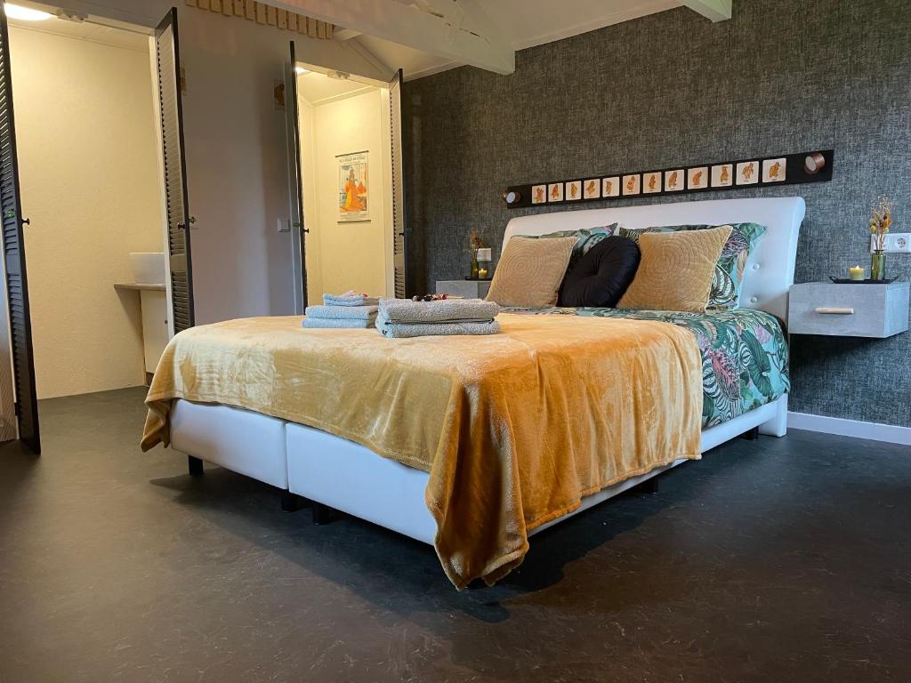 1 dormitorio con 1 cama grande con manta naranja en Bommeltje Boven 